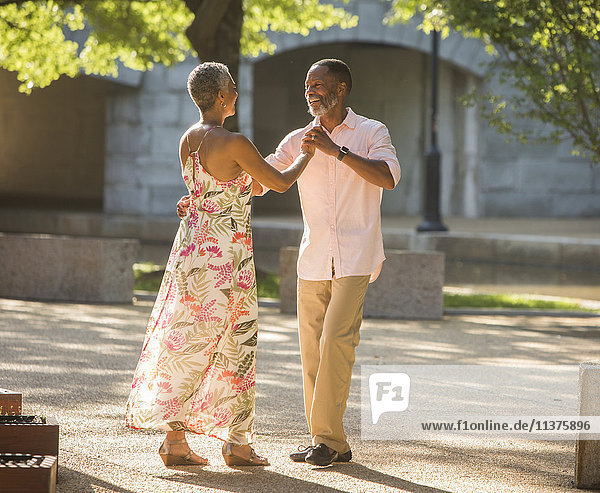 Black couple dancing in park