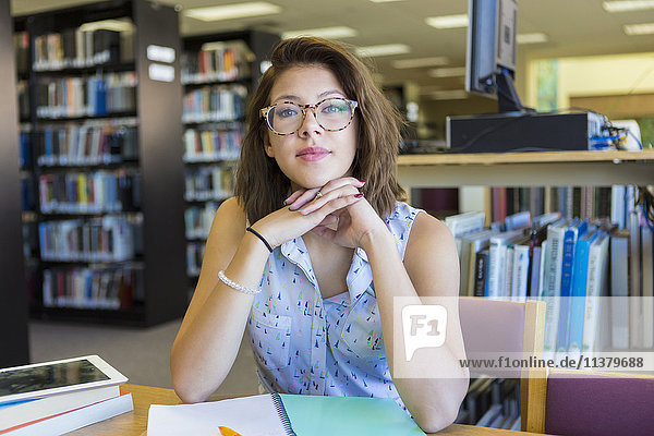 Porträt eines gemischtrassigen Mädchens in einer Bibliothek