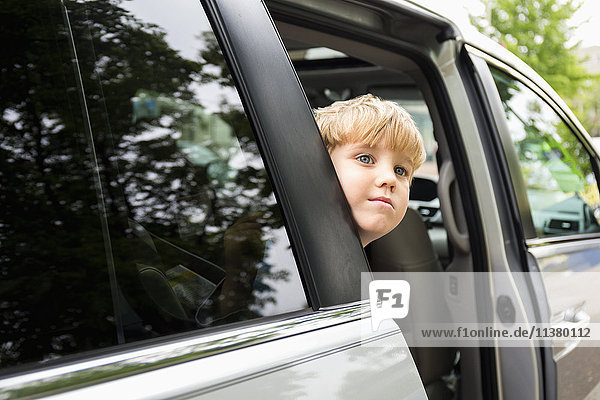Kaukasischer Junge wartet im Mini-Van