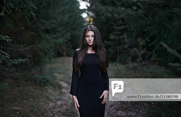 Kaukasische Frau in schwarzem Kleid im Wald