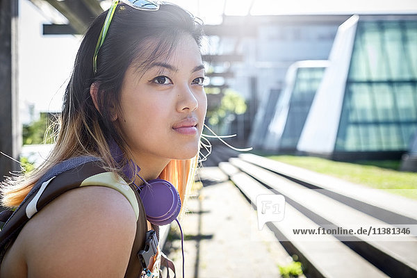 Porträt einer nachdenklichen chinesischen Frau mit Kopfhörern