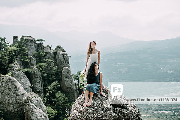 Frauen auf einem Felsen mit Blick auf die Landschaft