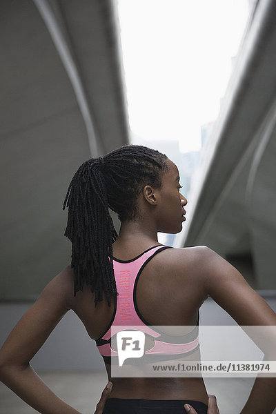 Mixed Race Frau läuft stehend unter städtischen Brücke