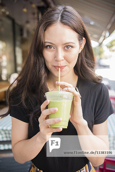 Thai woman drinking green smoothie