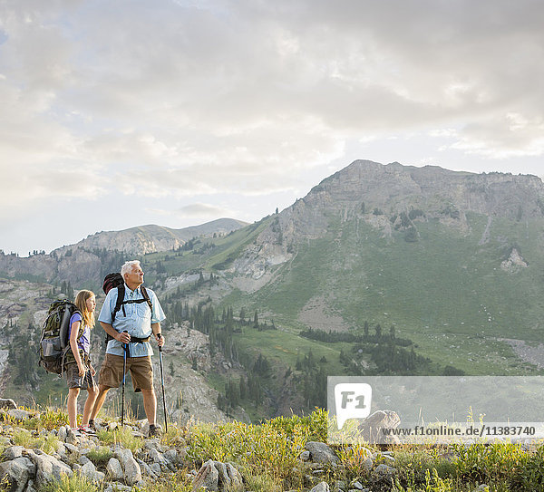 Caucasian grandfather and granddaughter hiking on mountain