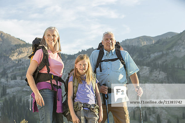 Caucasian grandparents and granddaughter hiking on mountain