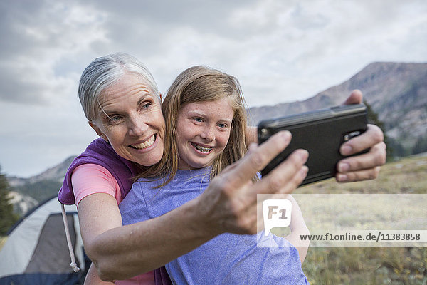 Kaukasische Großmutter und Enkelin posieren für ein Selfie mit dem Handy