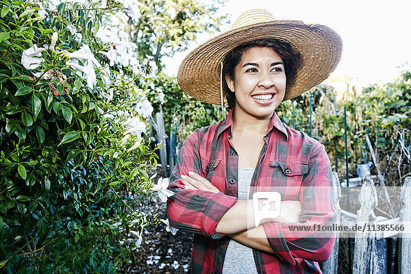 Lächelnde Mixed Race Frau im Garten stehend
