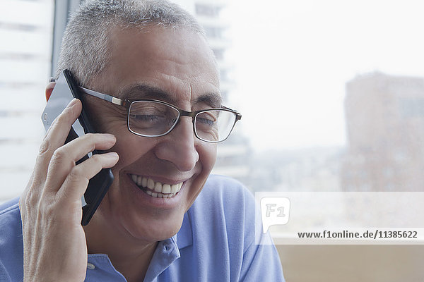 Smiling Hispanic man talking on cell phone