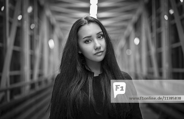 Portrait of serious Mixed Race teenage girl on footbridge