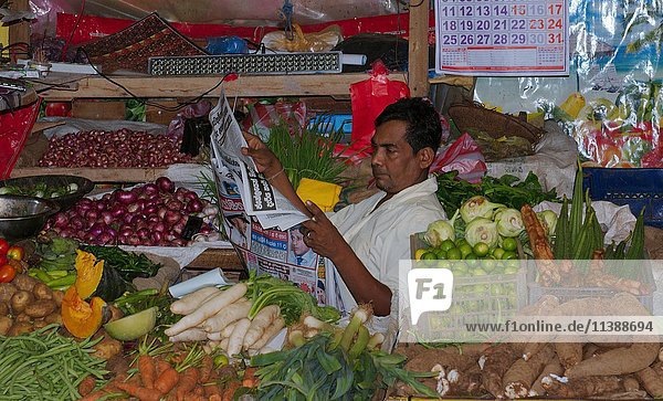 Seller reading newspaper  fruit market  Hikkaduwa  Sri Lanka  Asia