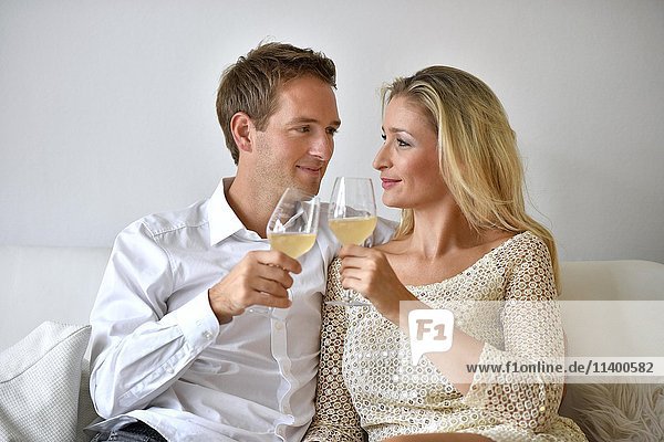 Mann  Frau  Paar auf Sofa  verliebt  Wein  Glas übereinander