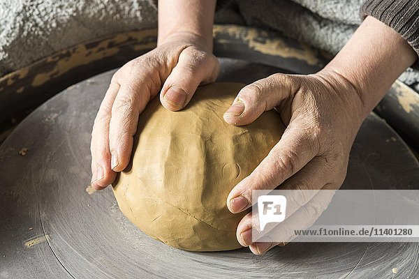 Keramische Werkstatt  Hände setzen Ton auf die Töpferscheibe  Pittenhart  Oberbayern  Deutschland  Europa