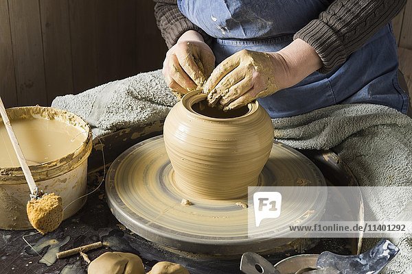 Keramikwerkstatt  Hände formen Ton mit Schwamm auf Töpferscheibe  Pittenhart  Oberbayern  Deutschland  Europa