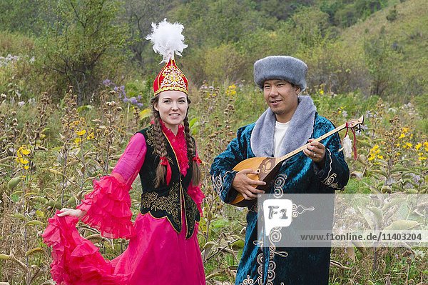 Kasachischer Mann singt und spielt die Dombra für eine Frau  Kasachisches ethnografisches Dorf aul Gunny  Talgar  Almaty  Kasachstan  Asien