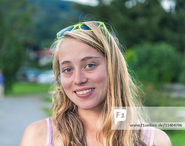 Junge Frau mit Sonnenbrille auf dem Kopf lächelt  Schliersee  Oberbayern  Bayern  Deutschland  Europa