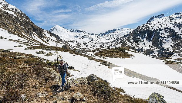 Young woman  hiker walking in mountain landscape with residual snow  Rohrmoos Obertal  Schladming Tauern  Schladming  Styria  Austria  Europe