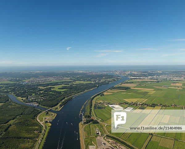 Fluss  der durch Ackerland fließt  hinter der Nordseeküste  nahe Amsterdam  Niederlande  Europa