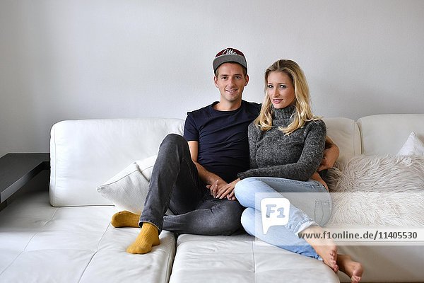 Junges Paar  Liebespaar auf Sofa sitzend