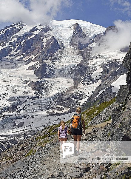 Hikers on skyline trail in front of snow capped Mount Rainier  Paradise Loop  Mount Rainier National Park  Cascade Range  Washington  Pacific Northwest  USA  North America