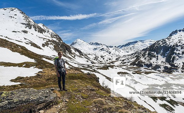 Young man  hiker walking in mountain landscape with residual snow  Rohrmoos Obertal  Schladming Tauern  Schladming  Styria  Austria  Europe