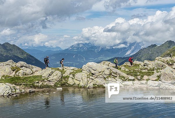 Hikers on trail by mountain lake  Klafferkessel  Rohrmoos-Untertal  Schladminger Tauern  Schladming  Styria  Austria  Europe