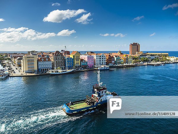 Tugboat  colorful row of houses in Punda district at back  commercial arcade  waterfront  World Heritage Site  Willemstad  Lesser Antilles  Curacao  North America