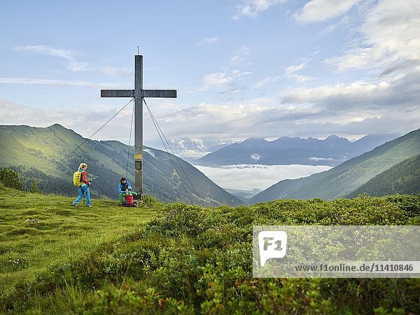 Hikers at summit cross  Kemater Alm  Kalkkögel  Tyrol  Austria  Europe