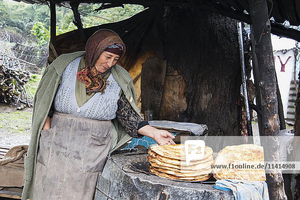 'Woman selling salyan coreyi (tandoor bread) by the road side; Sheki  Azerbaijan'