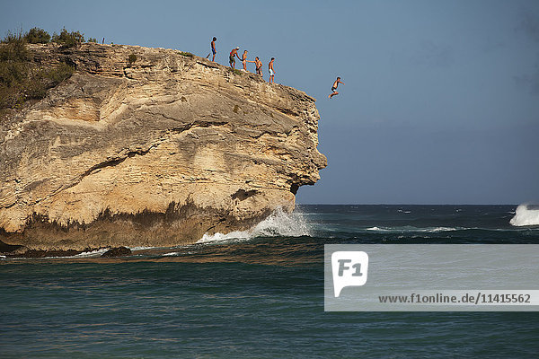 'Cliff jumping  Keoniloa Beach and Bay  also known as Ship Wreck Beach; Poipu  Kauai  Hawaii  United States of America'