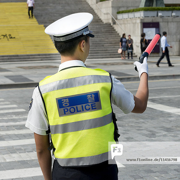 'Policeman directing traffic at a crosswalk; Seoul  South Korea'
