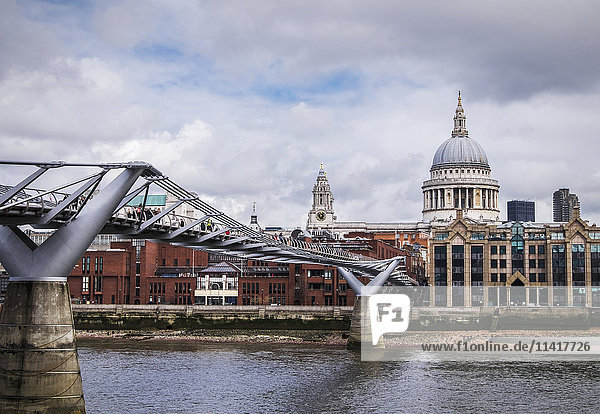 'View of the Millennium Bridge and St Paul's Cathedral from bankside of River Thames; London  England'