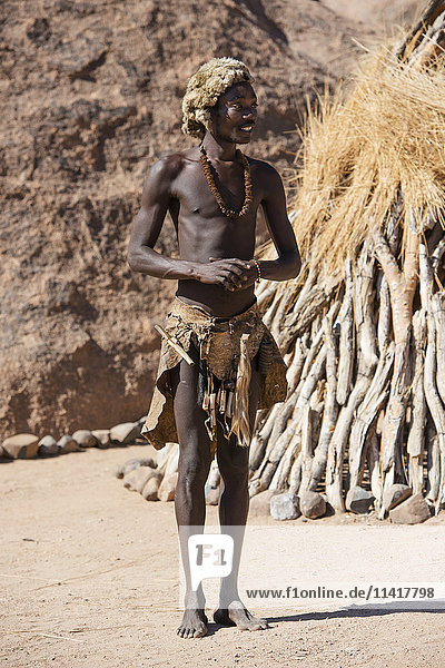 Ein junger Mann in traditioneller Damara-Kleidung posiert im Lebenden Museum der Damara; Namibia'.