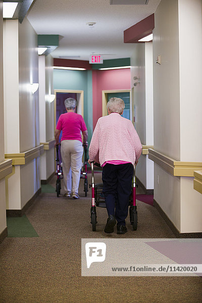'Senior Citizens Walking Down Shared Residence Hallway; Devon  Alberta  Canada'