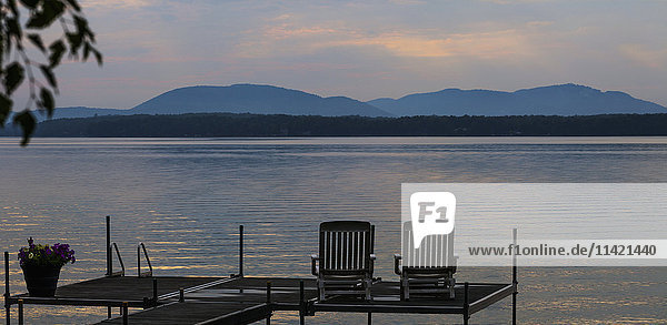 Sonnenuntergang am See mit Silhouetten von Stühlen am Kai; Knowlton  Quebec  Kanada'.