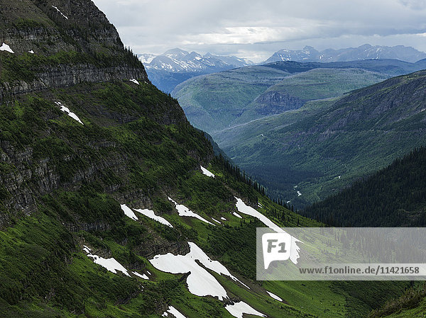 'Extreme terrain in mountain range under cloudy sky  Glacier National Park; Montana  United States of America'