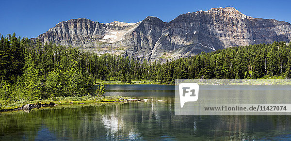 Panorama einer Bergkette  die sich in einem Bergsee mit blauem Himmel spiegelt; Banff  Alberta  Kanada'.