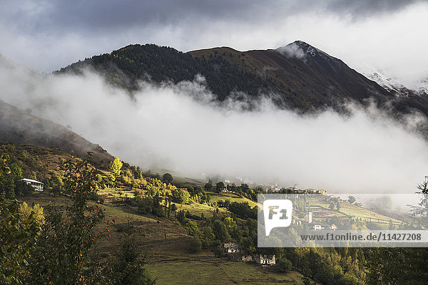 'Village with Svan towers between Mestia and Ushguli in low clouds  Upper Svaneti; Samegrelo-Zemo Svaneti  Georgia'