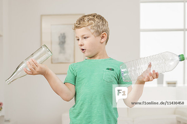 Kleiner Junge mit Einweg- und Mehrwegflasche