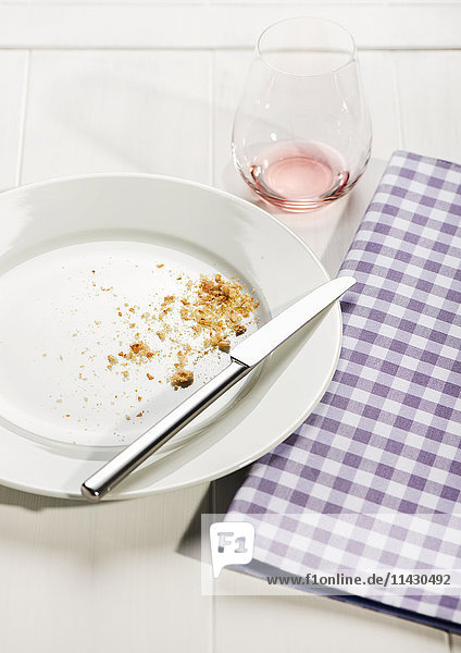 Gebrauchtes Geschirr mit karierter Serviette