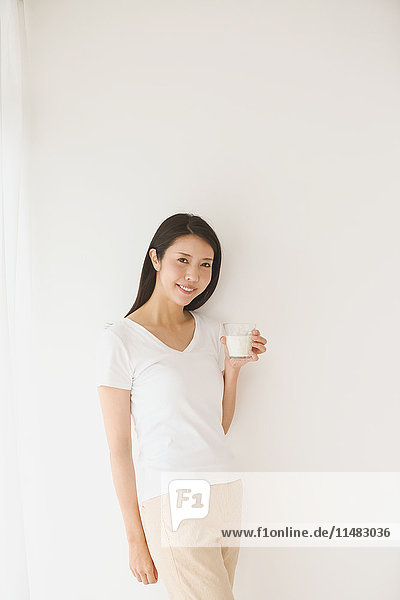 Portrait of young Japanese woman in a white room