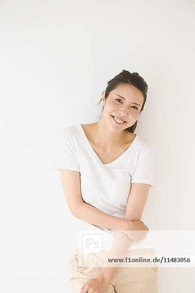 Portrait of young Japanese woman in a white room