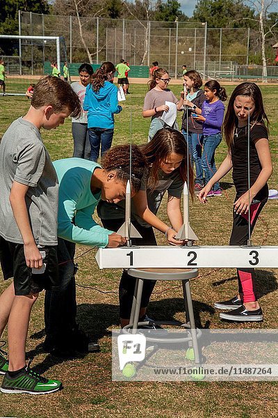 Multiracial Mission Viejo  CA  middle school students prepare to launch black powder rockets as part of their science curriculum. Note numbered launching rails.