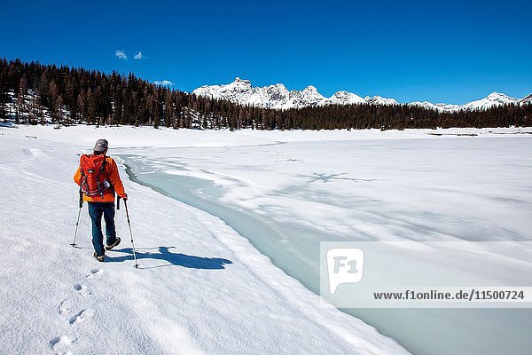 A hiker walking on the banks of Lake Palu now melting  Valmalenco  Valtellina  Italy.