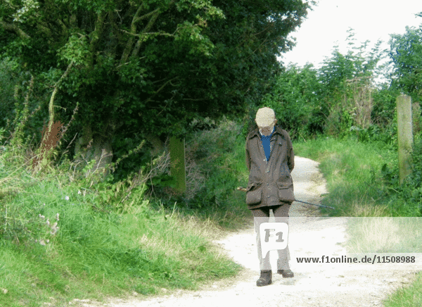 Älterer Mann auf Morgenspaziergang entlang eines ländlichen Weges