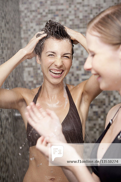 Two women having a shower and washing hair