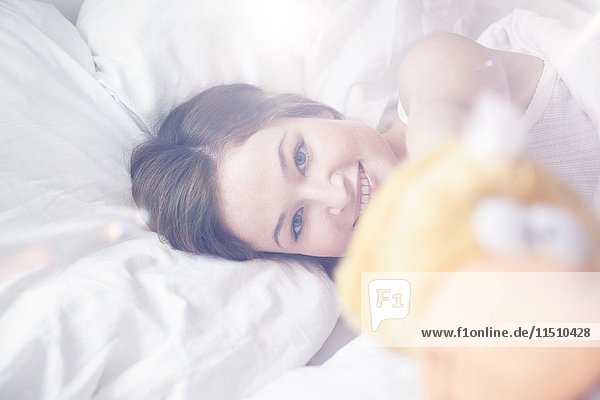 Junge Frau im Bett liegend