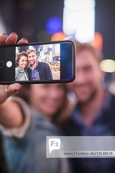 Young couple taking selfie while sightseeing in Times Square  New York City  New York  USA