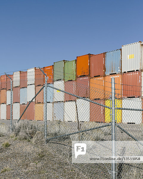 Stapel von bunten Schiffscontainern  im Vordergrund ein Zaun  Nevada  USA.