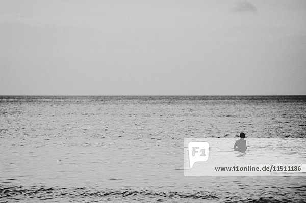 View across the Andaman Sea from Ko Lanta Yai  a person swimming in a vast ocean
